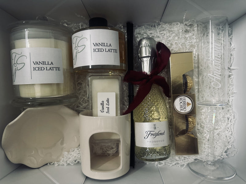 Women's Christmas Gift Box with candle, vanilla iced latte syrup, treats and glassware arranged neatly in a white box.